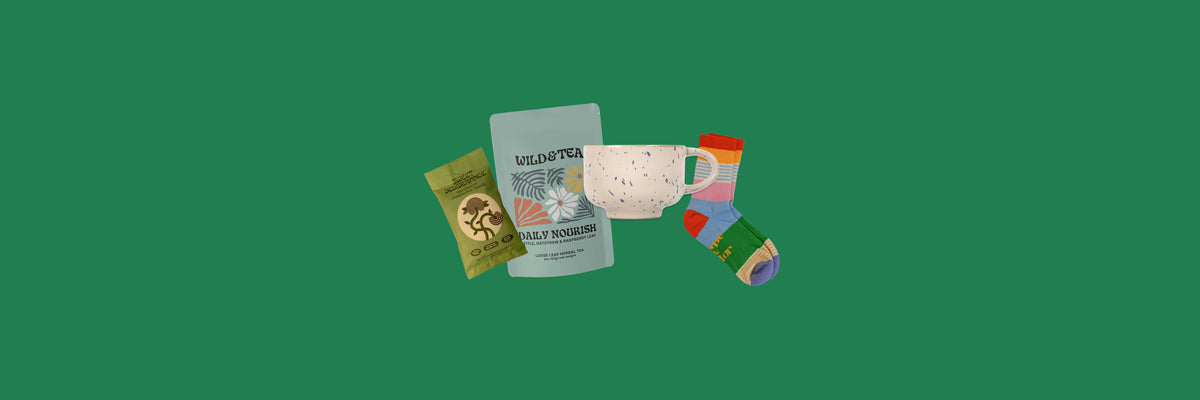 Granola pouch, loose leaf tea, speckled mug and striped socks on a green background